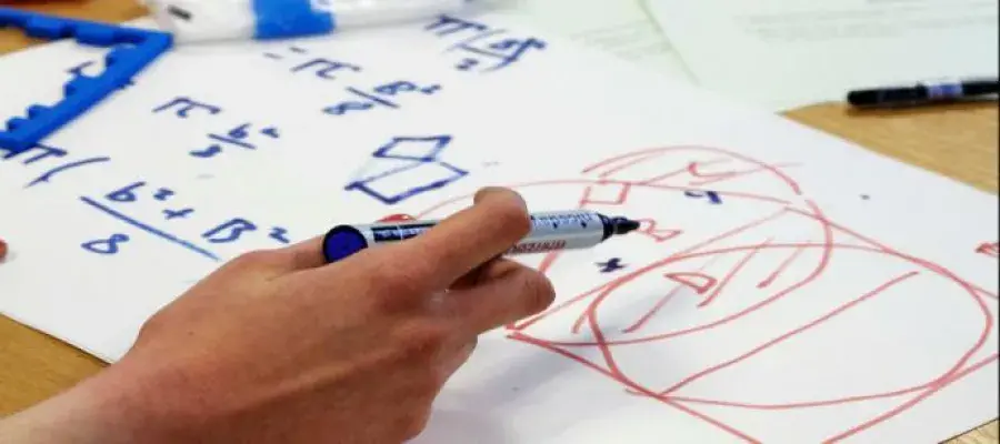 Image of an person writing facts and figures on large piece of paper. 